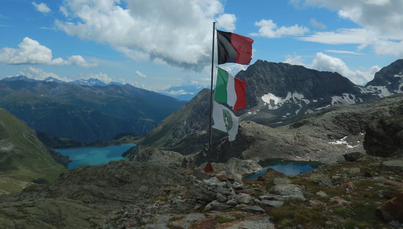 Le bandiere del Rifugio Perucca Vuillermoz tra il lago di Balanselmo e la diga di Cignana – Foto di Gian Mario Navillod.