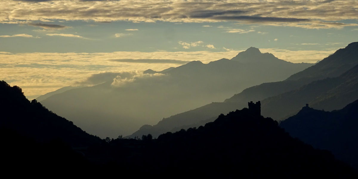 Tramonto sul castello di Ussel, sullo sfondo il castello di Cly - Foto di Gian Mario Navillod.