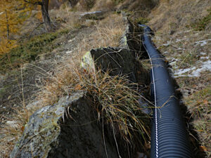 Tubazione in plastica del Ru di Cleva Bella di Chamois posata nel vecchio alveo (intervento reversibile) - Foto di Gian Mario Navillod del 2025.